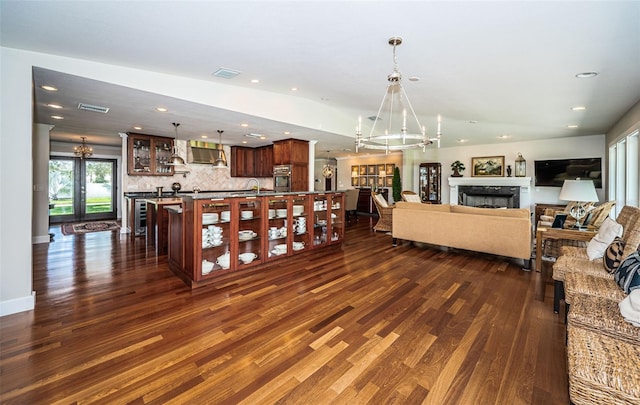 living room featuring french doors, a notable chandelier, sink, and dark hardwood / wood-style flooring