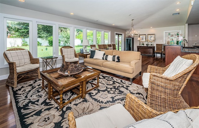 living room featuring dark hardwood / wood-style floors and an inviting chandelier