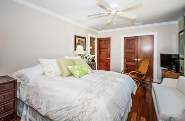 bedroom with crown molding, dark hardwood / wood-style flooring, ceiling fan, and a closet