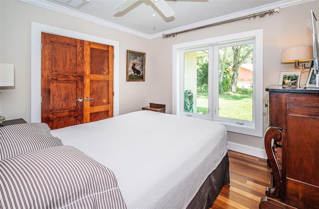 bedroom featuring light wood-type flooring, multiple windows, ceiling fan, and ornamental molding