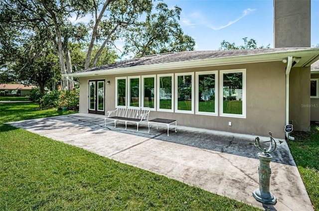 rear view of property with a lawn and a patio