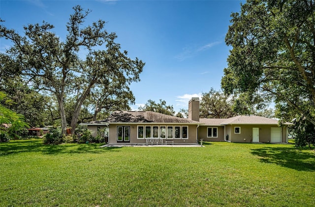 rear view of property featuring a lawn