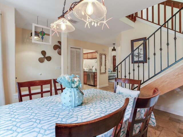 dining area with an inviting chandelier and sink