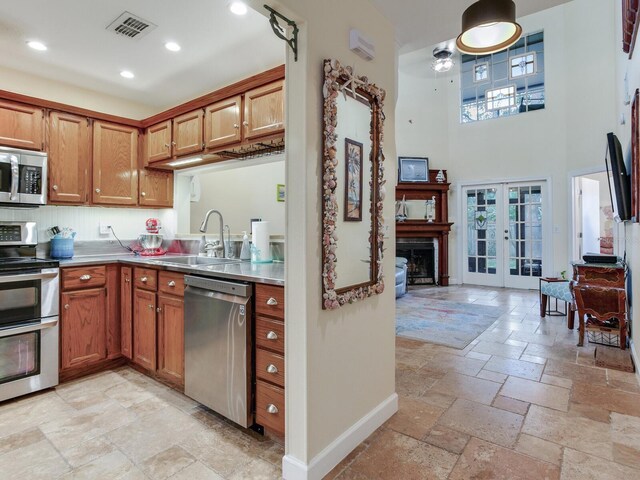 kitchen featuring appliances with stainless steel finishes, a wealth of natural light, sink, and french doors