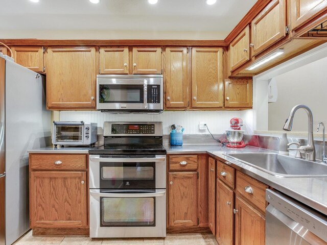 kitchen with light tile patterned floors, stainless steel appliances, and sink