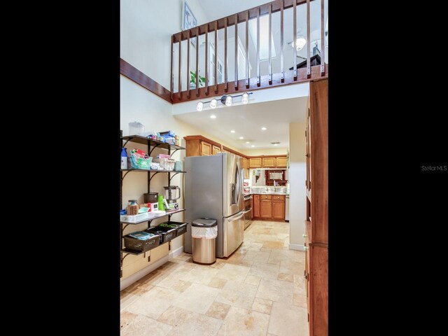 kitchen with a towering ceiling and stainless steel refrigerator with ice dispenser