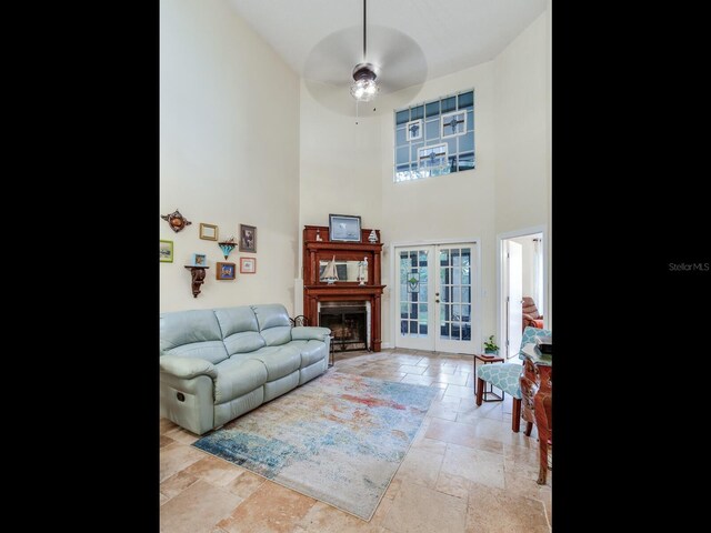 living room featuring french doors, a high ceiling, and ceiling fan