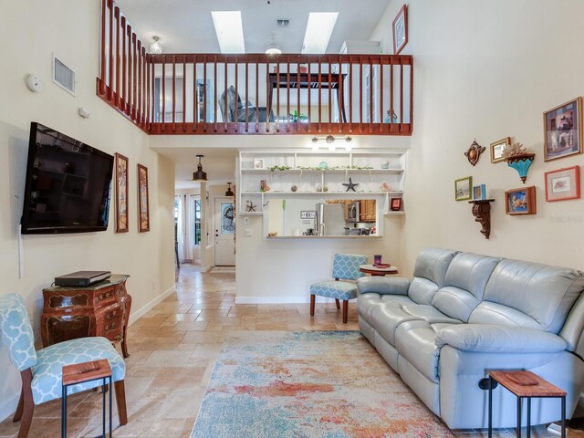 living room featuring a skylight and a towering ceiling