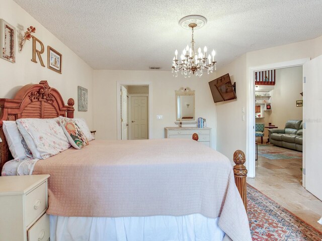 bedroom with a textured ceiling and an inviting chandelier