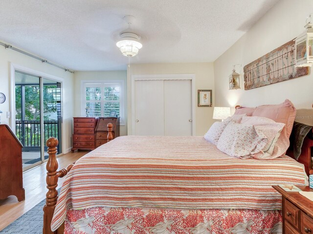 bedroom featuring a textured ceiling, access to outside, ceiling fan, a closet, and light hardwood / wood-style floors