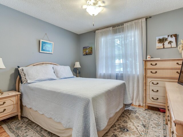 bedroom featuring a textured ceiling and light hardwood / wood-style flooring