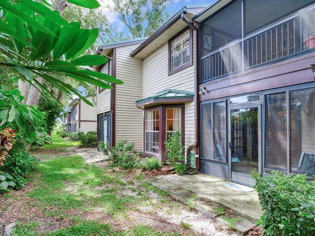 rear view of property featuring a sunroom