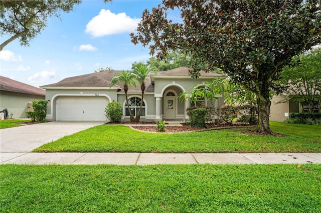 mediterranean / spanish home featuring a front lawn and a garage