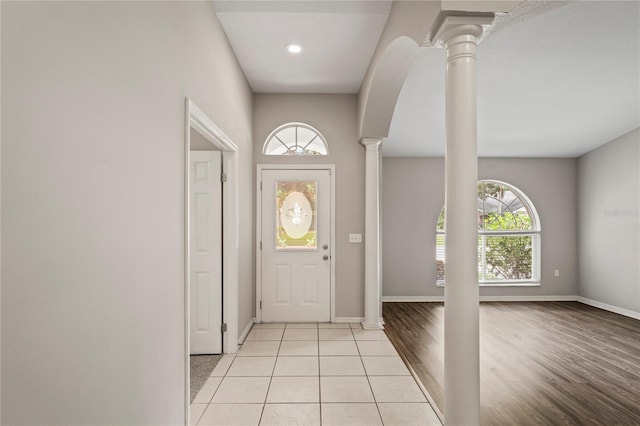 entryway featuring light hardwood / wood-style flooring and ornate columns