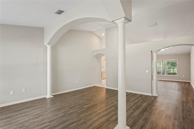 unfurnished living room featuring ornate columns, lofted ceiling, and dark hardwood / wood-style flooring