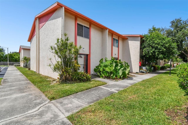 1655 58th Ter S Unit 1, Saint Petersburg, FL 33712 - view of home's exterior featuring stucco siding and a lawn