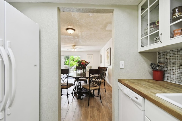 kitchen featuring white cabinetry, white appliances, a textured ceiling, ceiling fan, and light hardwood / wood-style flooring