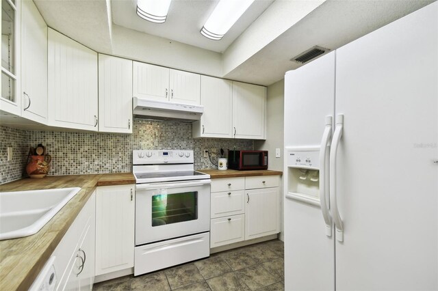 kitchen featuring white appliances, wood counters, tasteful backsplash, and white cabinets