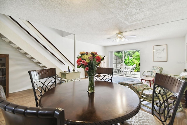 dining space featuring ceiling fan, a textured ceiling, and light hardwood / wood-style flooring