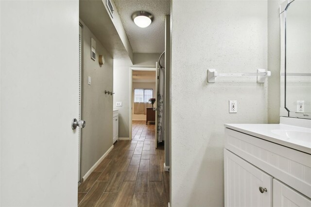 bathroom with vanity, a textured ceiling, and hardwood / wood-style flooring