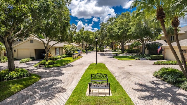 view of property's community featuring a garage and a lawn