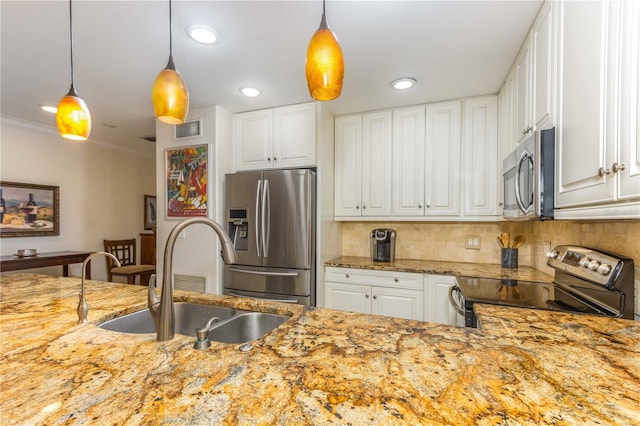 kitchen featuring white cabinetry, sink, hanging light fixtures, stainless steel appliances, and decorative backsplash