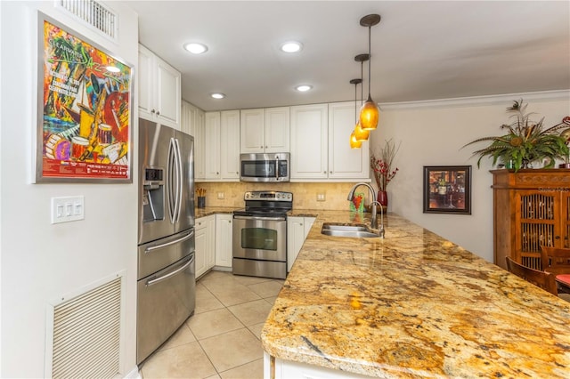 kitchen featuring pendant lighting, stainless steel appliances, white cabinetry, and sink