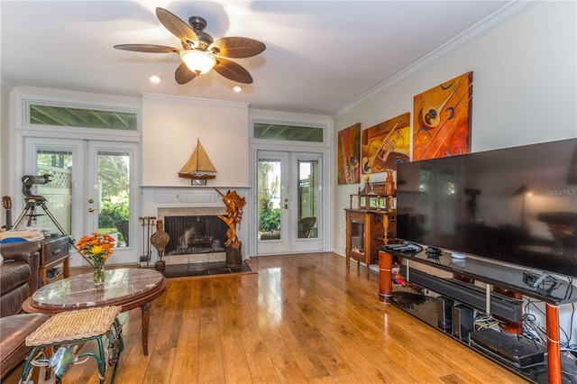 living room with french doors, ceiling fan, ornamental molding, and wood-type flooring