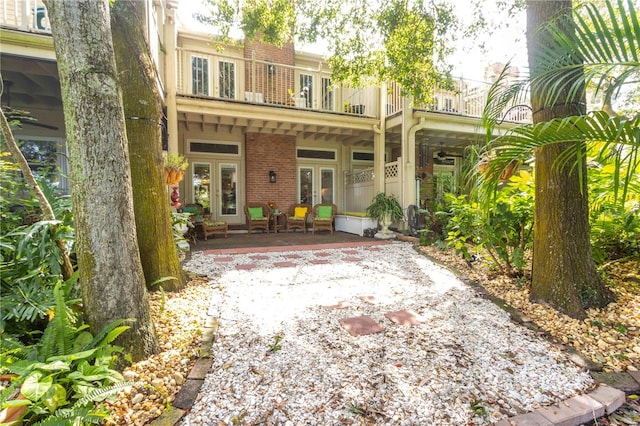 rear view of property featuring french doors and a balcony