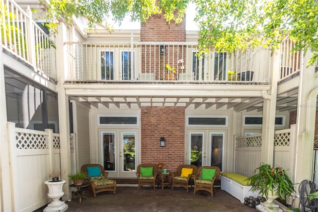 back of house with a balcony, a patio, and french doors