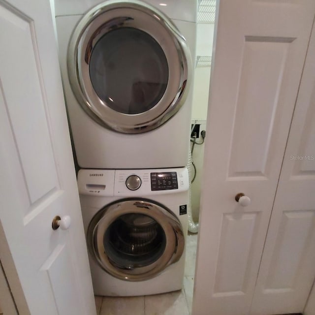 washroom featuring tile patterned flooring and stacked washer and clothes dryer