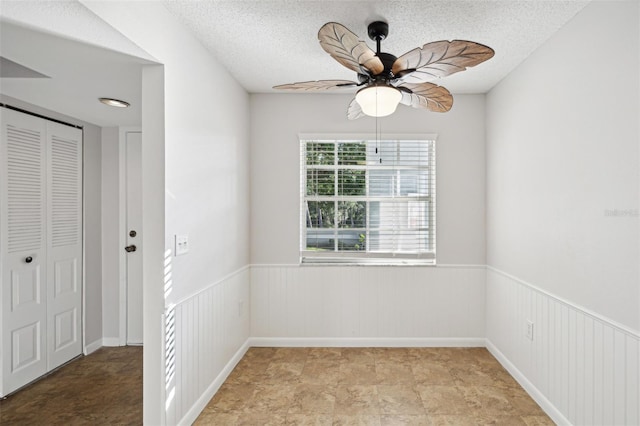 empty room featuring ceiling fan and a textured ceiling