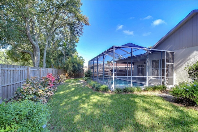 view of yard with a fenced in pool and glass enclosure