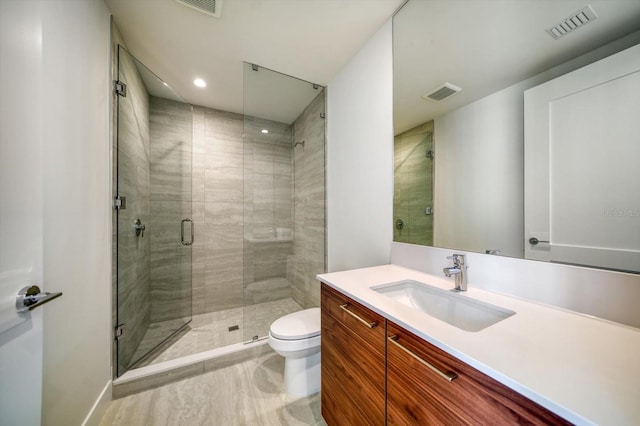 bathroom featuring an enclosed shower, vanity, and toilet