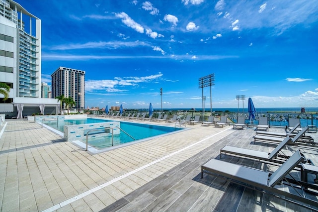 view of pool with a hot tub and a water view