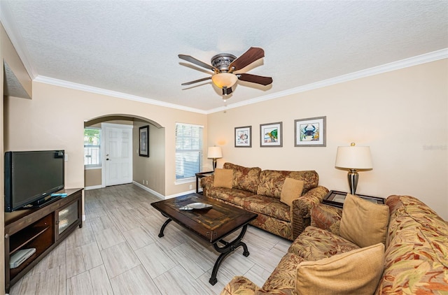 living room featuring ornamental molding, ceiling fan, and a textured ceiling