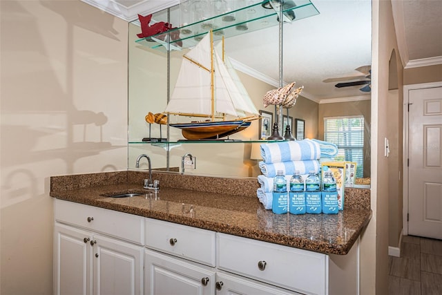 kitchen featuring white cabinets, ceiling fan, crown molding, and sink