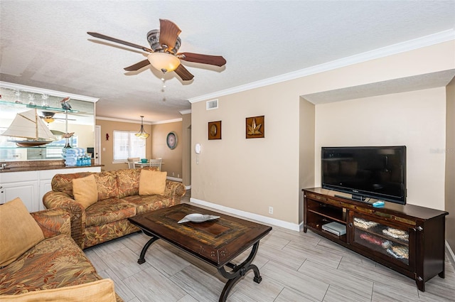 living room featuring a textured ceiling, ceiling fan, and crown molding