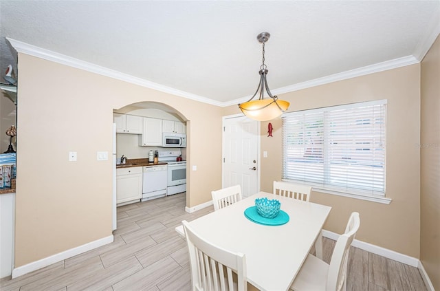 dining room featuring ornamental molding, sink, and light hardwood / wood-style floors