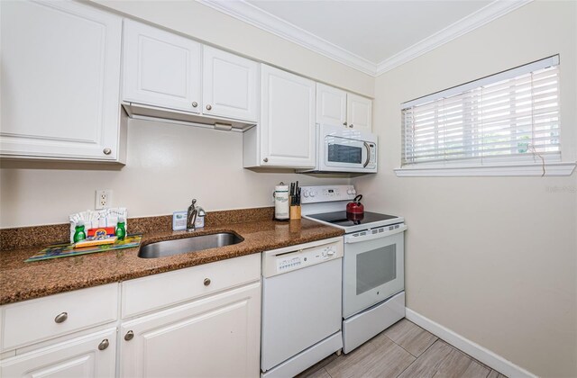 kitchen featuring white cabinets, white appliances, crown molding, dark stone counters, and sink