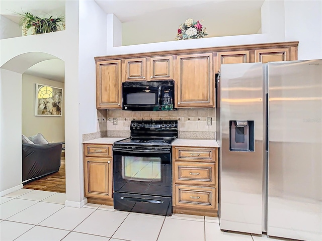 kitchen featuring black appliances, backsplash, and light tile patterned floors