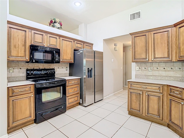 kitchen featuring light tile patterned flooring, tasteful backsplash, and black appliances