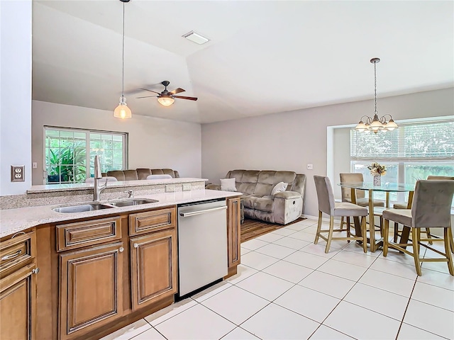 kitchen with dishwasher, sink, ceiling fan with notable chandelier, light tile patterned floors, and decorative light fixtures