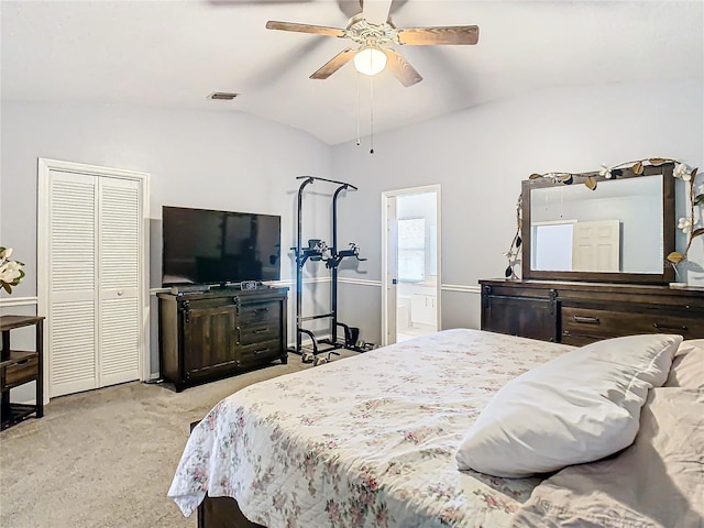 carpeted bedroom featuring a closet, connected bathroom, lofted ceiling, and ceiling fan