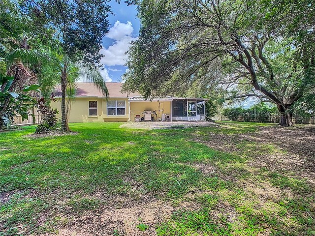 back of property featuring a lawn and a sunroom