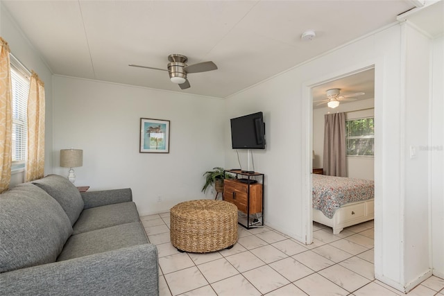 tiled living room with ceiling fan and crown molding