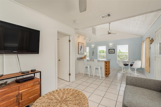 tiled living room featuring ceiling fan and lofted ceiling