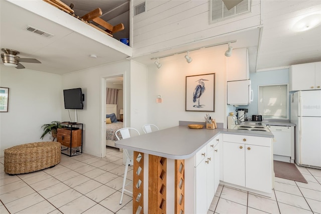 kitchen with ceiling fan, kitchen peninsula, white appliances, and white cabinetry