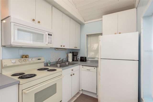 kitchen featuring tile patterned flooring, sink, white cabinets, lofted ceiling, and white appliances