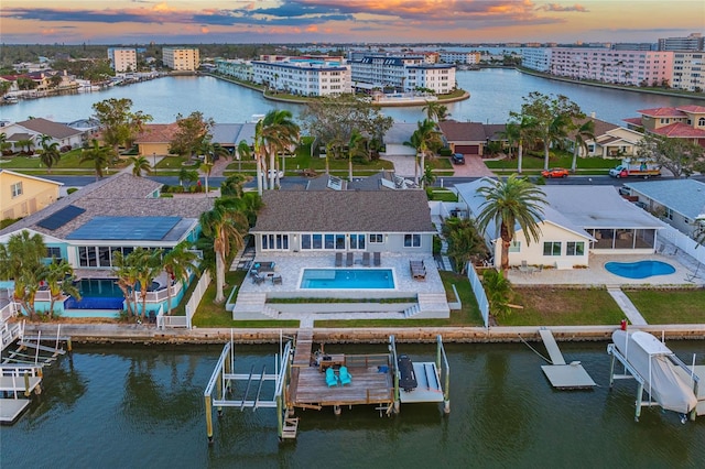 aerial view at dusk featuring a water view